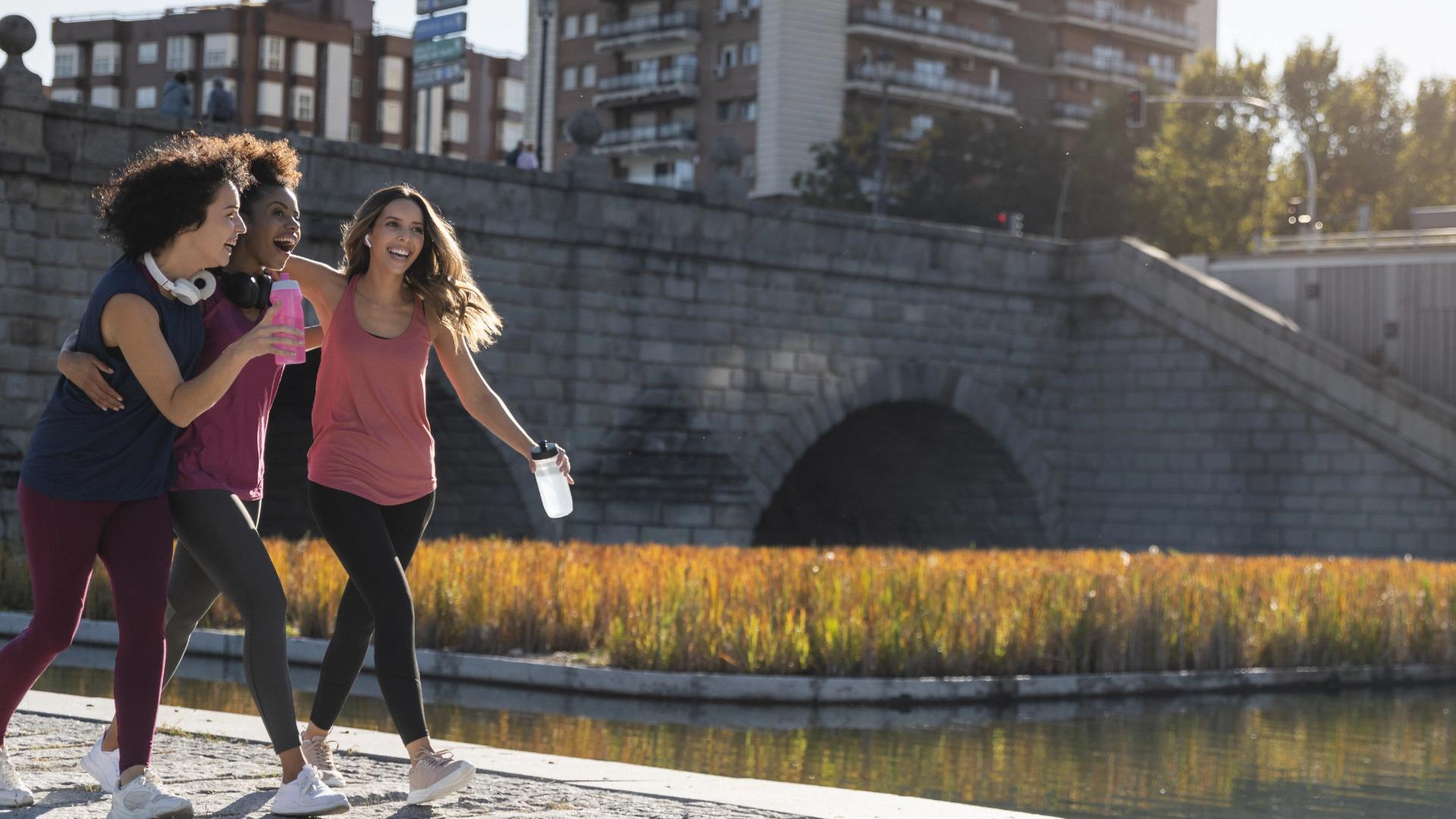 trois femmes font du footing sur le quai d'une ville