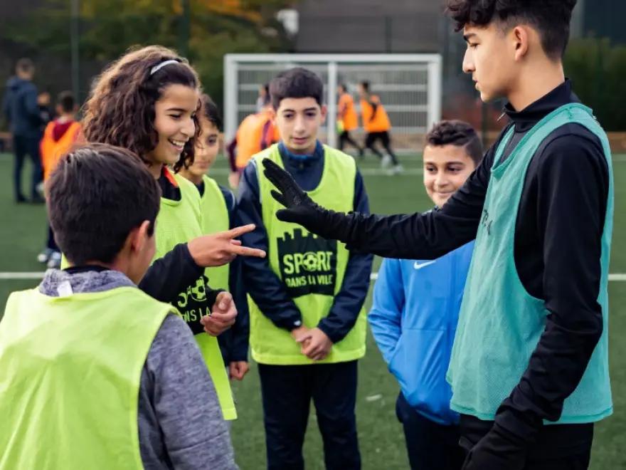 des enfants en tenu de sport font un pierre feuille ciseau